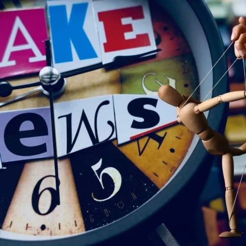 Image containing the text "fake news" and a wooden puppet being controlled by strings metaphorically depicting modern media manipulation.